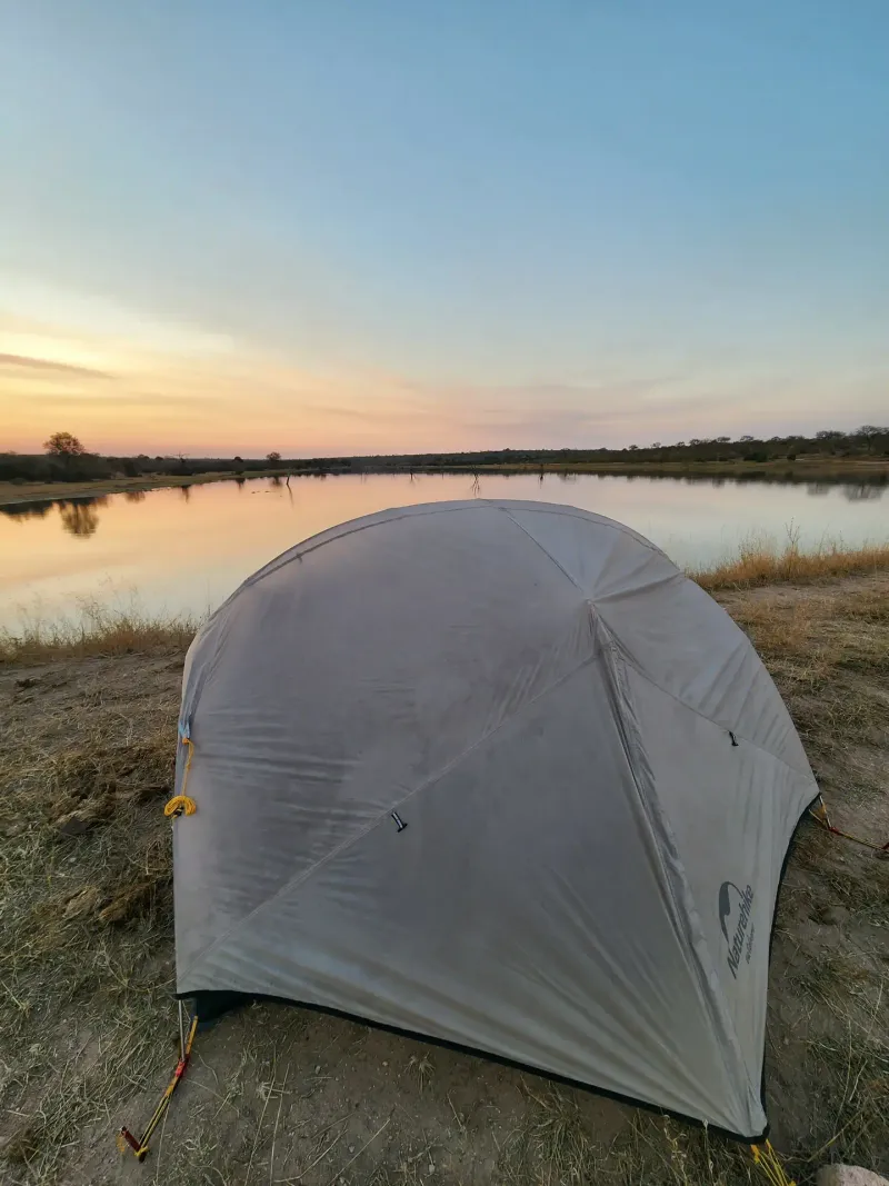 Safari camping tent pitched at sunset lakeside