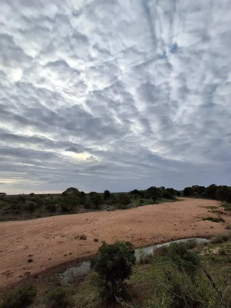 Dramatic cloudy sky over sandy African riverbed